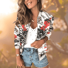 Frau in modischer Blumenjacke, weißem Top und Jeansshorts. Trendige Damenmode, lässiger Sommerlook, stilvolle Freizeitkleidung.