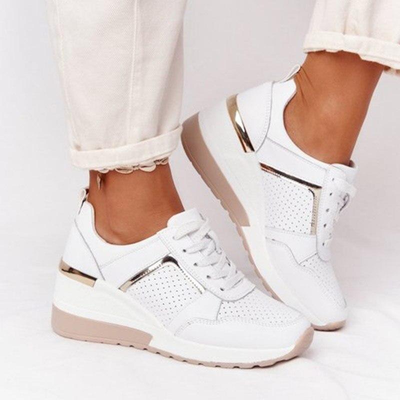 Weiße orthopädische Sneakers für Damen, bequem und stilvoll, mit Keilabsatz und goldenen Akzenten. Ideal für schmerzfreie, modische Auftritte.