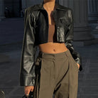 Schwarze Kunstlederjacke, kurz geschnitten, Y2K-Stil, mit Umlegekragen und Knopfdetails, ideal für Grunge- und Streetwear-Looks.