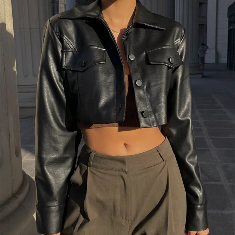 Schwarze Kunstlederjacke, kurz geschnitten, mit Umlegekragen und Knopfdetails. Perfekt für Y2K-Mode, Grunge-Stil und Streetwear.