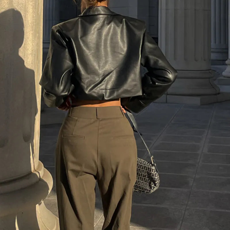 Schwarze Kunstlederjacke im Y2K-Stil mit Umlegekragen und Knopfdetails, kombiniert mit lässiger Hose. Perfekt für Grunge- und Streetwear-Looks.