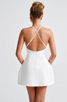 Weißes Minikleid mit überkreuzten Trägern, elegantes Design, ideal für Sommermode und Partys. Hochwertige Damenbekleidung, stilvoll und modern.