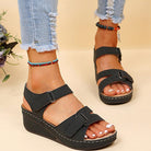 Schwarze Damen-Sandalen mit Keilabsatz, verstellbaren Riemen und bequemer Sohle. Perfekt für Sommermode und lässige Outfits.