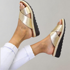 Goldene Sandalen mit Kreuzriemen, bequemer schwarzer Sohle und modernem Design. Perfekt für Sommermode und lässige Outfits.