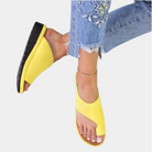 Gelbe Sandalen mit Zehenschlaufe, kombiniert mit bestickten Jeans. Modische Sommerschuhe, bequem und stilvoll für Damen.