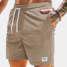 Khaki Badeshorts für Herren mit Kordelzug, geripptem Stoff und Taschen. Ideal für Sommer, Strand und Freizeit. Modisch und bequem.