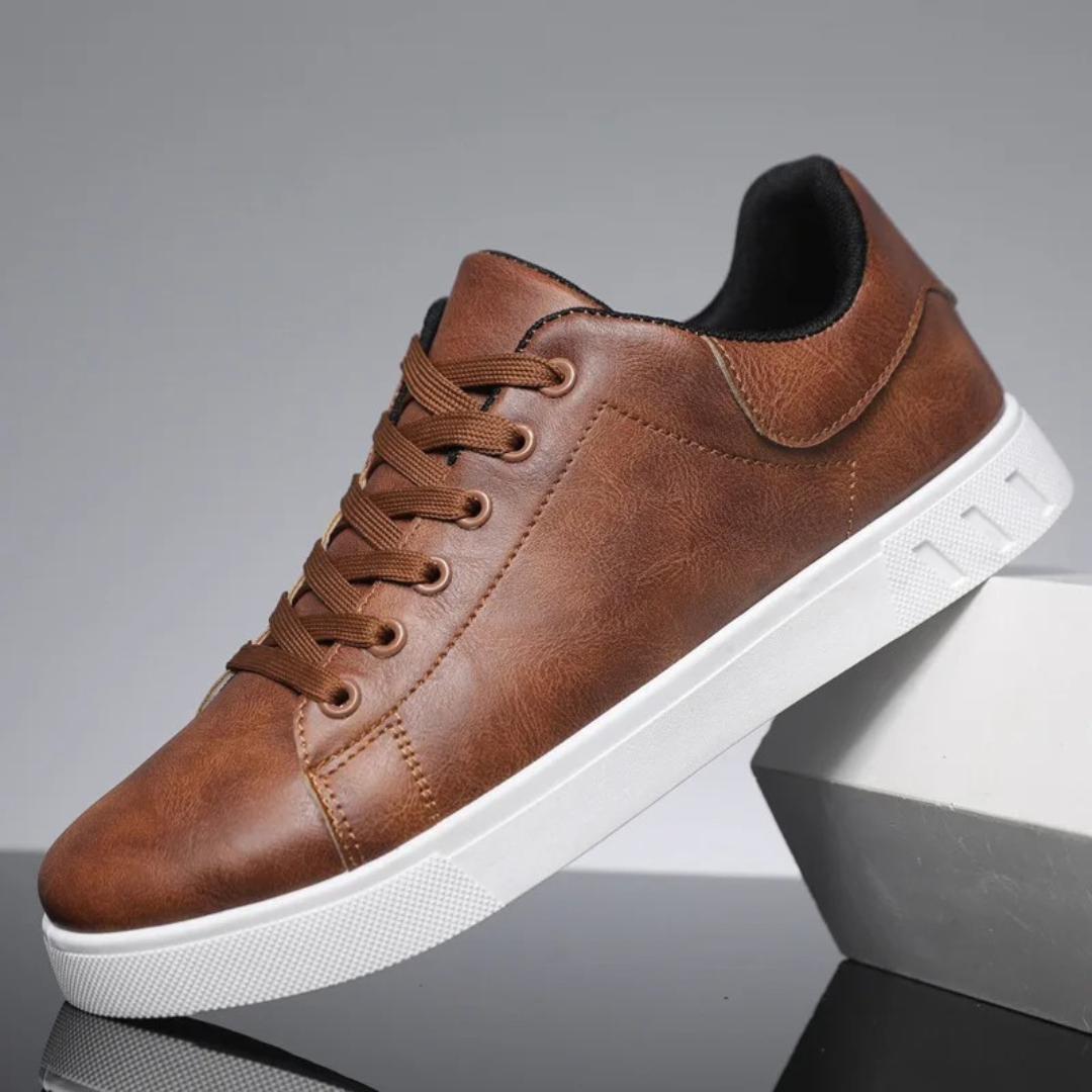 Dunkelbrauner Sneaker aus Lederimitat mit weißer Sohle, ideal für Herrenmode. Bequeme Freizeitschuhe, perfekt für Alltag und Freizeit.