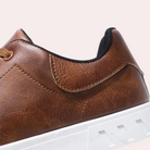 Brauner Ledersneaker mit weißer Sohle, modisches Design, ideal für Herren. Hochwertige Materialien, komfortabel und stilvoll.