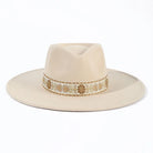 Eleganter beiger Fedora-Hut mit breiter Krempe und dekorativem Band. Perfekt für Vintage-Mode, Unisex-Design, ideal für stilvolle Anlässe.