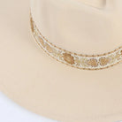Eleganter Fedora-Hut in Beige mit dekorativem Band, ideal für Herren und Damen. Perfekt für Vintage-Mode und stilvolle Outfits.