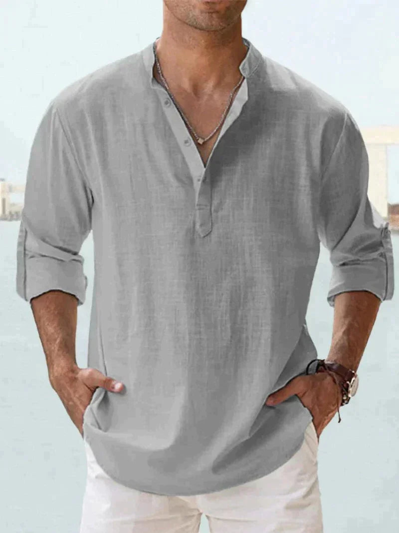 Graues Leinenhemd für Herren, lässig und atmungsaktiv, ideal für Sommermode. Perfekt kombinierbar mit weißen Hosen für einen eleganten Look.