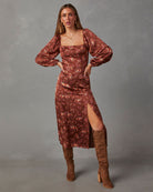 Braunes Blumenkleid mit langen Ärmeln und Beinschlitz, kombiniert mit kniehohen Stiefeln. Perfekt für Herbstmode und elegante Anlässe.
