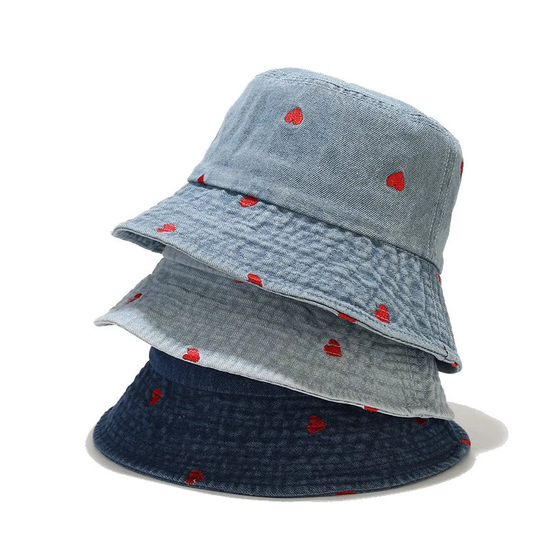 Drei Vintage-Bucket-Hüte aus gewaschenem Denim mit roten Herzmotiven, ideal für Damen und Herren im Frühling, Sommer und Herbst. Trendige Modeaccessoires.