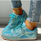 Glitzernde, hellblaue Sneaker mit Pailletten und Schnürsenkeln, kombiniert mit zerrissenen Jeans. Modische, auffällige Schuhe für Damen.