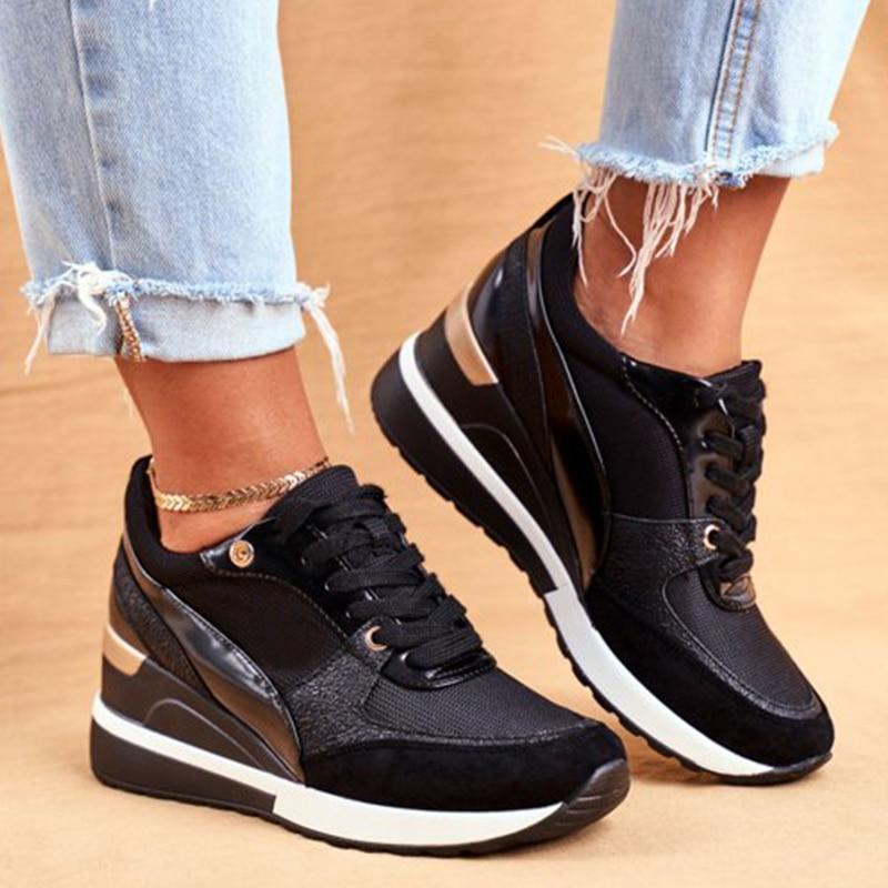 Schwarze Damen-Sneaker mit goldenen Akzenten, kombiniert mit hellblauen Jeans. Modische Turnschuhe, ideal für Freizeit und Streetwear.