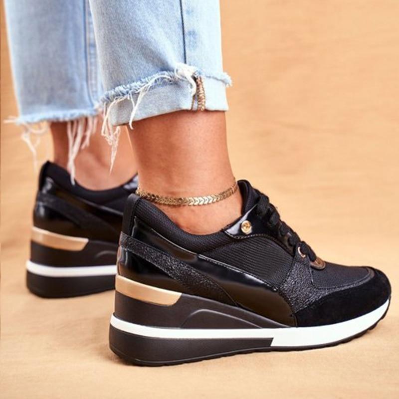 Schwarze Damen-Sneaker mit Keilabsatz, goldenen Details und Textil-Mix. Modische Schuhe für Freizeit und Sport. Perfekt für trendige Outfits.