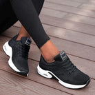 Schwarze Damen-Sneaker mit weißer Sohle, atmungsaktivem Mesh-Obermaterial, ideal für Sport und Freizeit. Bequeme, modische Turnschuhe.