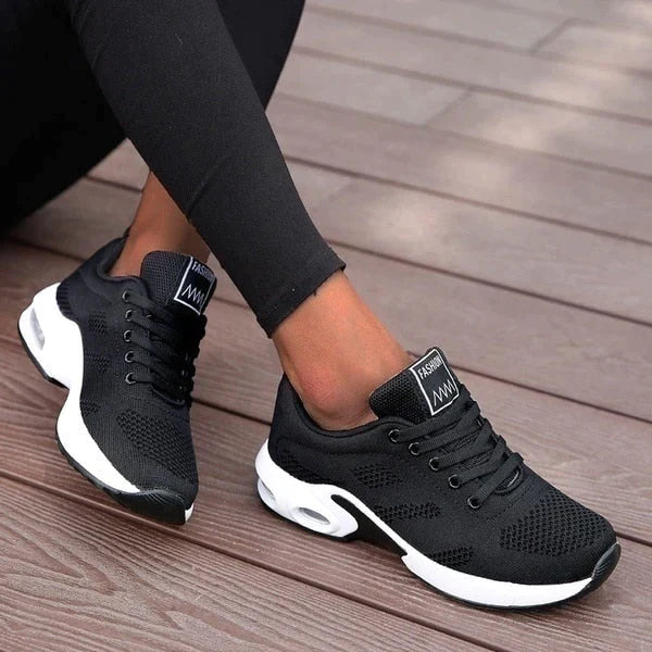Schwarze Damen-Sneaker mit weißer Sohle, atmungsaktivem Mesh-Obermaterial, ideal für Sport und Freizeit. Bequeme, modische Turnschuhe.