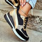 Goldene und schwarze Sneaker für Damen, modisch und bequem, ideal für Freizeit und Sport. Trendige Schuhe mit Keilabsatz und Schnürung.