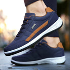 Dunkelblaue Sneaker mit braunen Akzenten, ideal für Herren. Bequeme Sportschuhe mit weißer Sohle, perfekt für Freizeit und Sport.