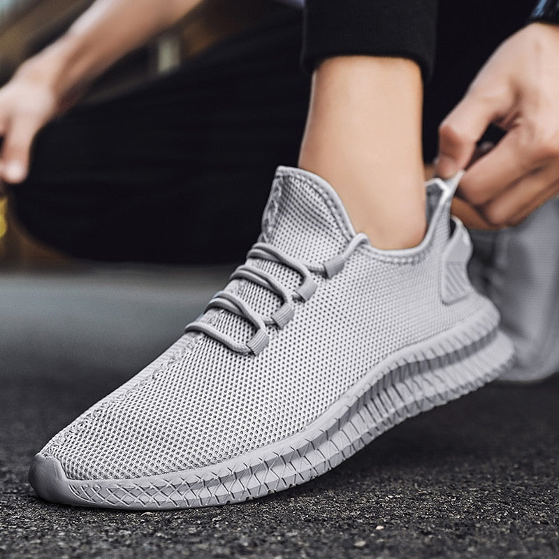 Grauer Sneaker mit atmungsaktivem Mesh-Obermaterial, ideal für Sport und Freizeit. Bequeme Passform, rutschfeste Sohle, modisches Design.