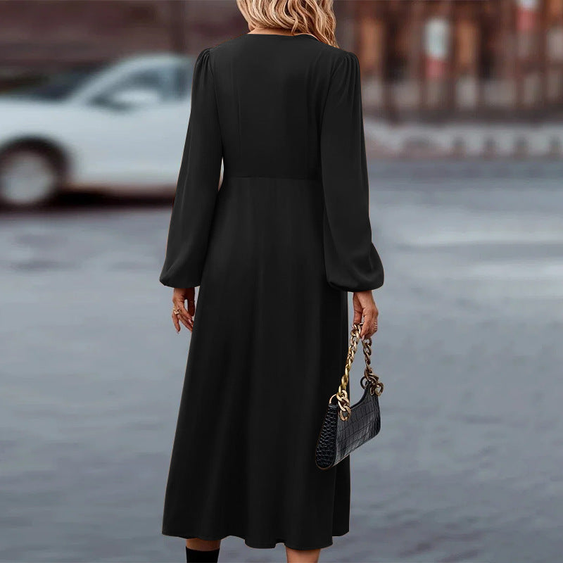 Elegantes schwarzes Maxikleid mit langen Ärmeln, kombiniert mit einer stilvollen Krokodilleder-Handtasche. Perfekt für Abendveranstaltungen.