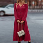 Elegantes rotes Kleid mit Knopfleiste und langen Ärmeln, kombiniert mit einer stilvollen, gesteppten Handtasche. Perfekt für modische Anlässe.