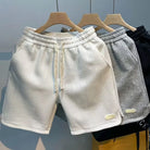 Drei Herren-Shorts aus Eisseide, schnell trocknend, atmungsaktiv, in Weiß, Grau und Schwarz.