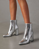 Silberne Damenstiefeletten mit Blockabsatz, glänzendem Finish und seitlichem Reißverschluss. Perfekt für modische Outfits und elegante Anlässe.
