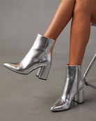 Silberne Stiefeletten mit Blockabsatz, glänzendem Finish und seitlichem Reißverschluss. Modische Damenstiefel, ideal für trendige Herbst-Looks.