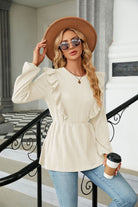Elegante Frau in cremefarbenem Pullover mit Rüschen, Sonnenbrille und Hut, hält Kaffeebecher. Modetrends, Damenmode, Herbstoutfit, Streetstyle.