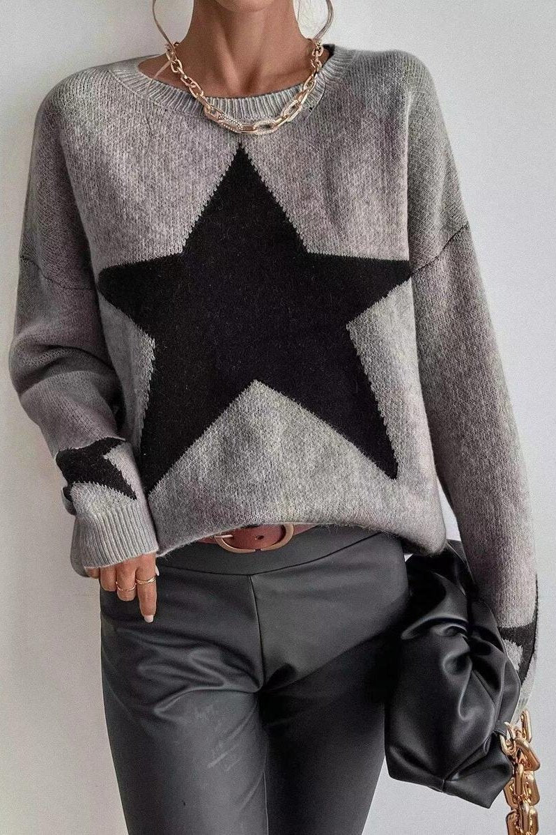 Damenpullover mit großem schwarzen Stern, kombiniert mit schwarzer Lederhose. Modischer Look, ideal für Herbst und Winter. Trendige Damenmode.