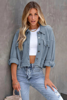 Frau in blauer Jeansjacke, weißem Top und Jeans. Modetrend, lässiger Look, Damenmode, Streetstyle, stilvolle Freizeitkleidung.