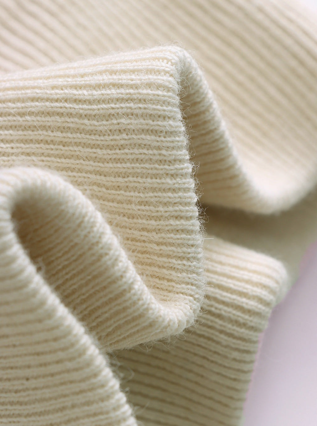 Beigefarbener Strickstoff, weiche Textur, ideal für Pullover und Strickwaren. Hochwertiges Material, perfekt für modische DIY-Projekte.