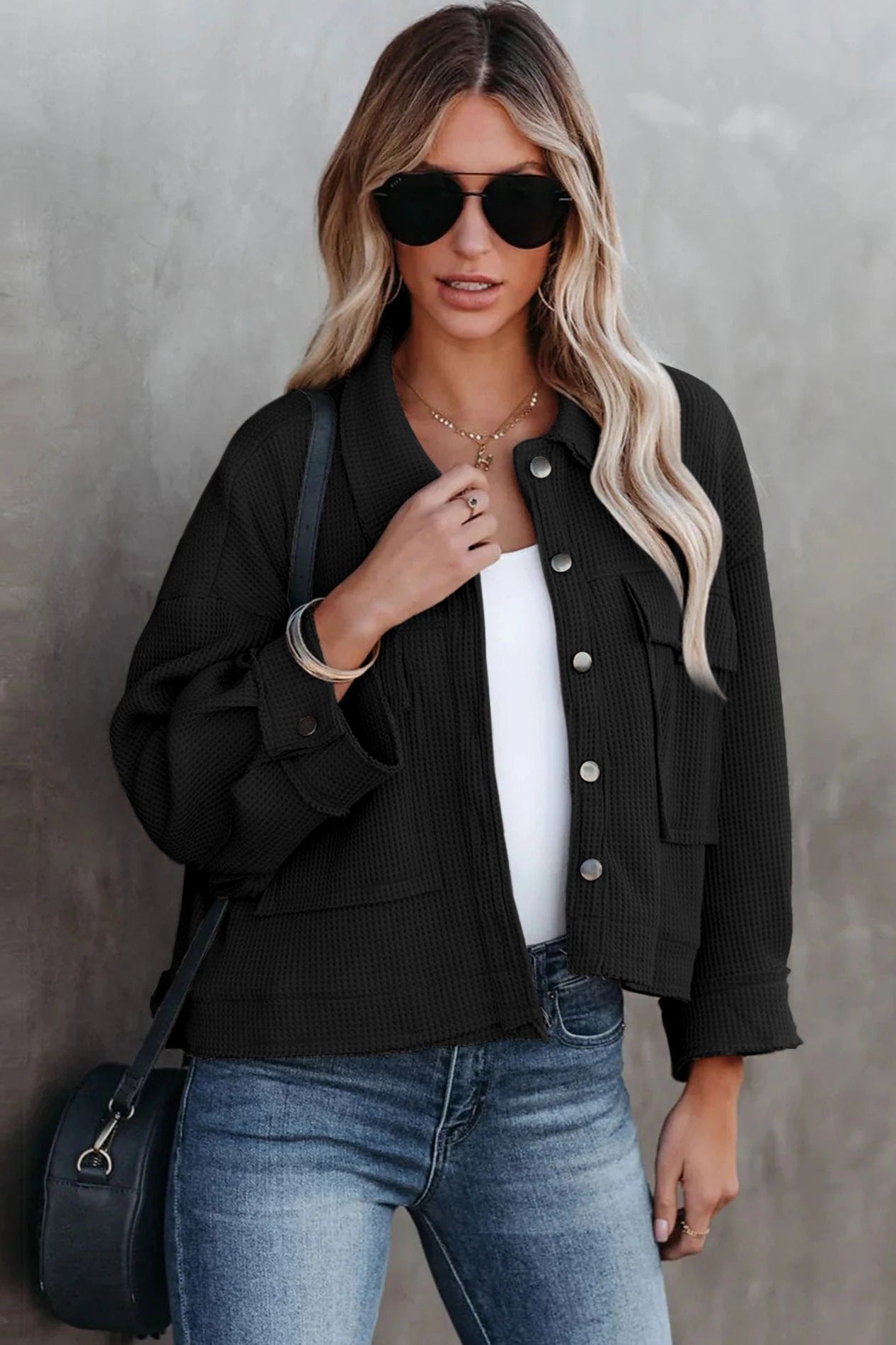 Damenmode: Schwarze Jacke mit Knopfleiste, lässig geschnitten, kombiniert mit blauer Jeans. Perfekt für trendige Herbst-Looks.