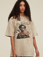 Frau mit lockigem Haar trägt ein oversized T-Shirt mit Grafikdruck. Modetrend, Streetwear, lässiger Stil, urbaner Look, Damenmode.