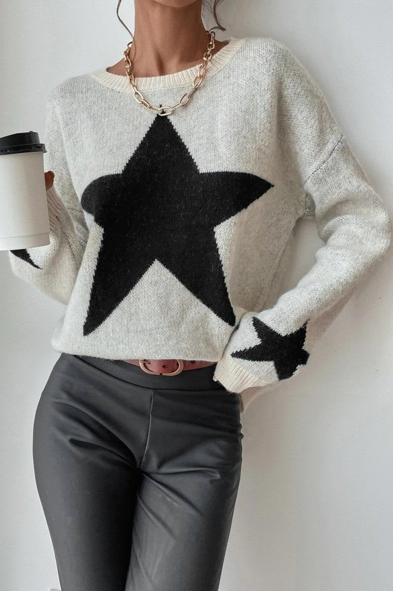 Damenpullover mit großem Sternmuster, kombiniert mit schwarzer Lederhose. Trendige Mode, lässiger Stil, ideal für Herbst und Winter.