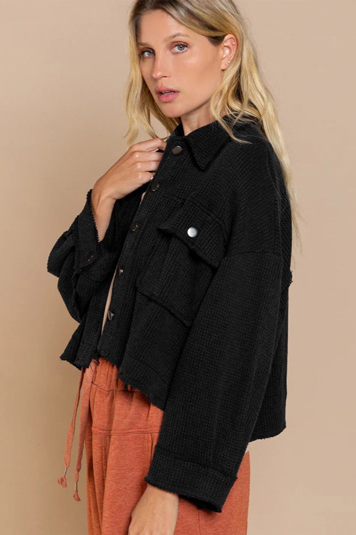 Schwarze Damenjacke, lässig geschnitten, mit Knopfleiste und Brusttaschen. Perfekt für Herbstmode, kombiniert mit orangefarbenen Hosen.