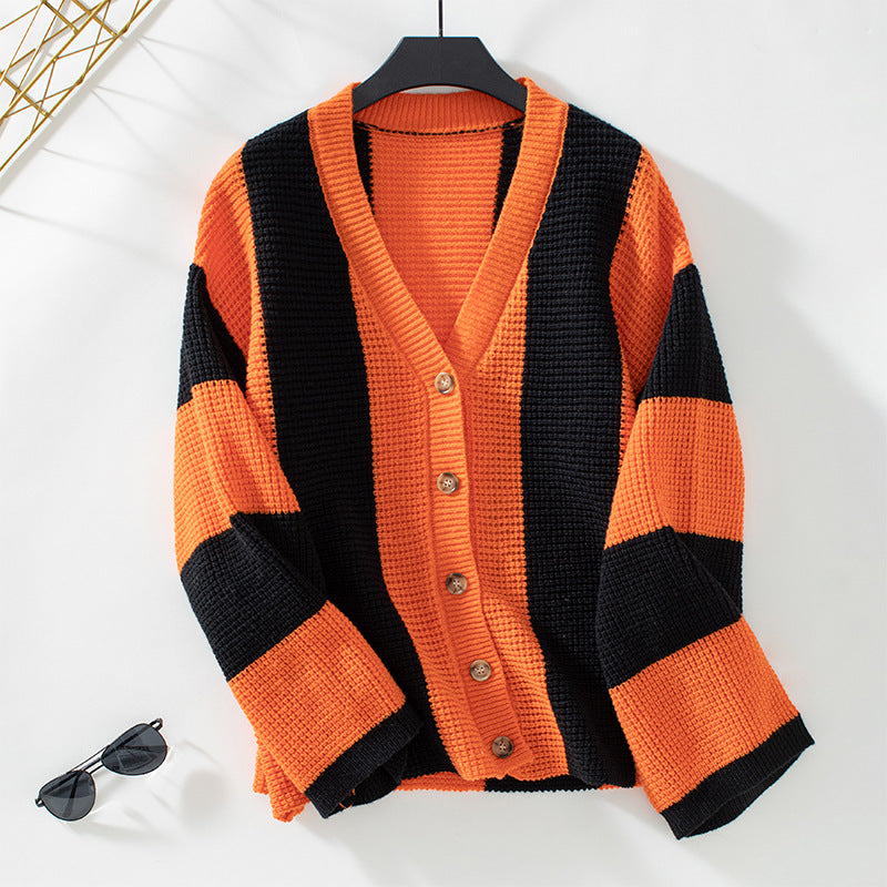 Damen-Strickjacke in Schwarz-Orange mit V-Ausschnitt und Knöpfen. Modischer Herbst-Look, ideal für stilvolle Outfits.