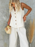Elegantes Damen-Outfit in Weiß mit ärmelloser Bluse und weiter Hose. Perfekt für Sommermode. Accessoire: Fendi-Tasche. Ideal für stilvolle Anlässe.
