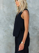 Elegantes schwarzes ärmelloses Damenoberteil, ideal für Sommermode. Perfekt kombiniert mit Goldschmuck. Trendige Damenbekleidung.