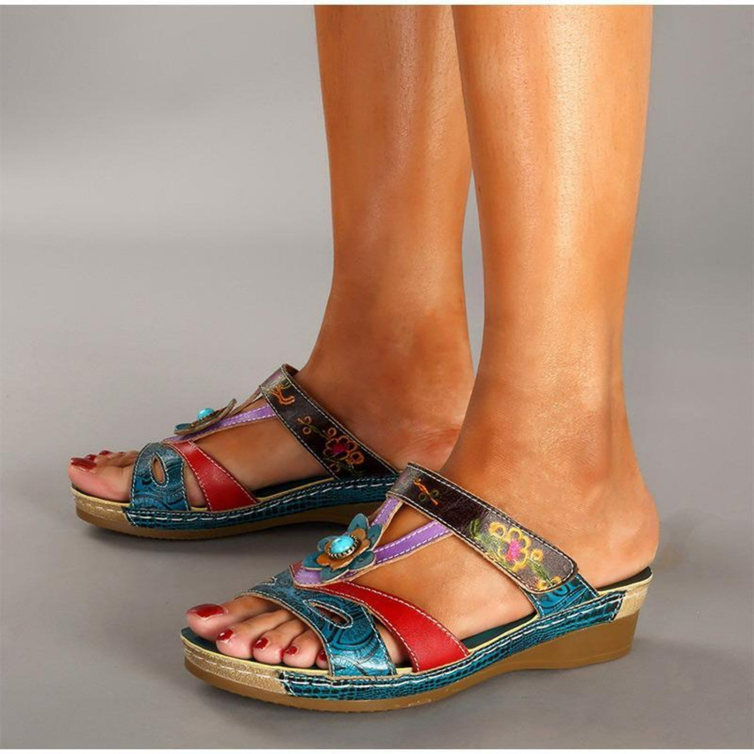 Bunte Damen-Sandalen mit Keilabsatz, floralen Mustern und Schmetterlingsdetails. Bequeme Sommerschuhe, ideal für Freizeit und Strand.