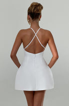 Weißes Minikleid mit Rückenausschnitt und überkreuzten Trägern, elegantes Design, ideal für Sommermode und besondere Anlässe.