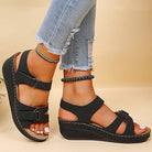 Schwarze Damen-Sandalen mit Keilabsatz, verstellbaren Riemen und bequemer Passform. Perfekt für Sommermode und lässige Outfits.