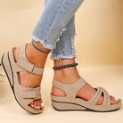 Beige Sandalen mit Keilabsatz, Klettverschluss und gepolsterter Sohle, ideal für Sommermode. Perfekt kombinierbar mit Jeans und Accessoires.