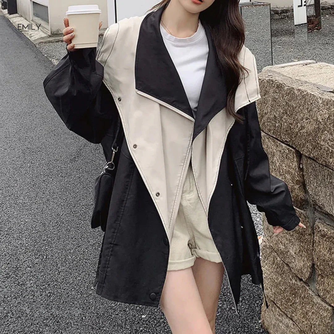 Frau in stilvoller zweifarbiger Jacke, hält Kaffeebecher. Trendige Mode, urbaner Look, Herbst-Outfit, Streetstyle, lässige Eleganz.