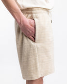 Beige Shorts aus weichem Stoff mit elastischem Bund und Seitentaschen, ideal für Sommermode. Perfekt für lässige und bequeme Outfits.