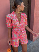 Frau in buntem Sommerkleid mit Puffärmeln und Taillengürtel, modisch und elegant, ideal für Sommermode und trendige Outfits.
