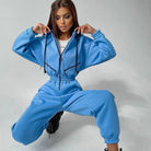 Frau in blauem Jogginganzug, sportlich, modisch, Freizeitkleidung, Hoodie, bequeme Passform, Streetwear, trendig, Damenmode, lässiger Stil.