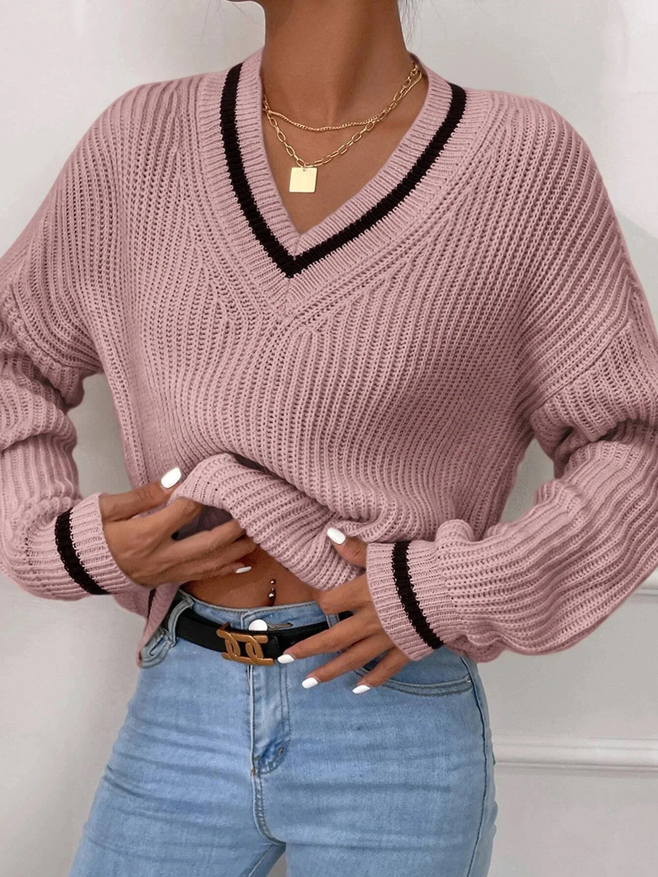 Damen-Pullover in Rosa mit V-Ausschnitt, geripptem Strickmuster und schwarzen Akzenten. Modischer Look, ideal für Herbstmode und Freizeitkleidung.